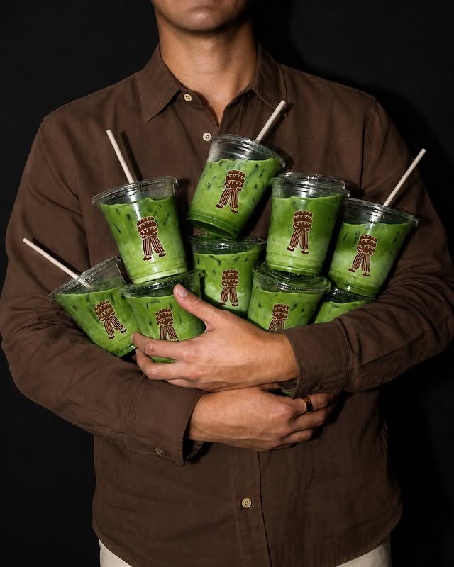 Persona sosteniendo varios vasos de matcha helado de Tres Panes