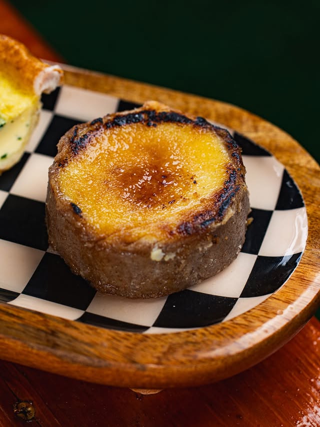 Pastel individual caramelizado sobre un plato de cuadros blancos y negros
